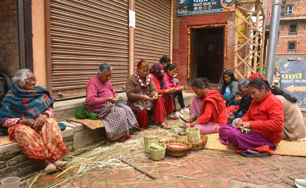 नयाँ पुस्तालाई निगालोका सामग्री बुन्ने सीप सिकाउँदै ज्येष्ठ नागरिक